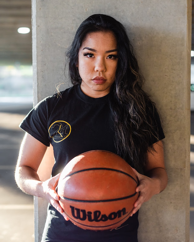 Jan holding a basketball looking at the camera