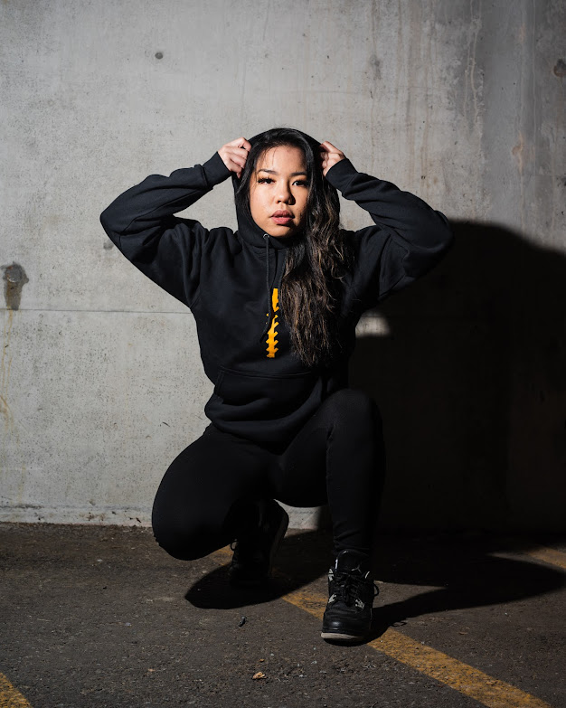 Jan crouching putting on her hoodie